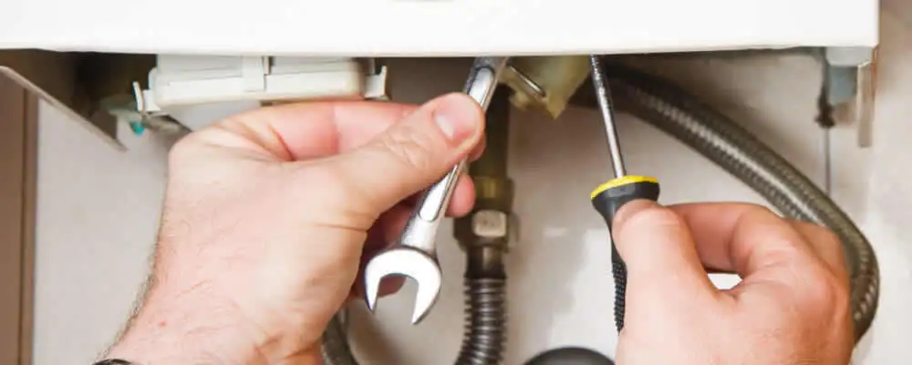 Boiler repair technician tightening pipe fittings and connections in Portland, OR