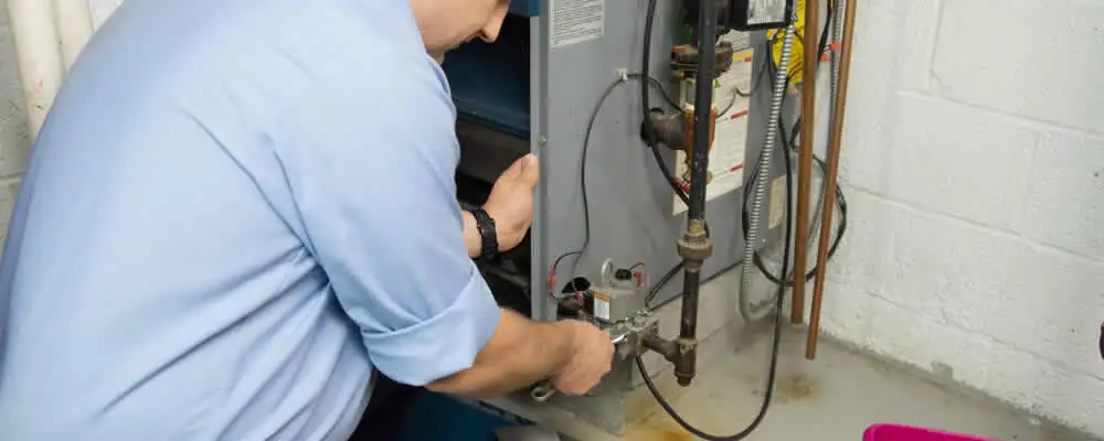 Furnace repair technician inspecting and servicing a home heating system in Portland, OR