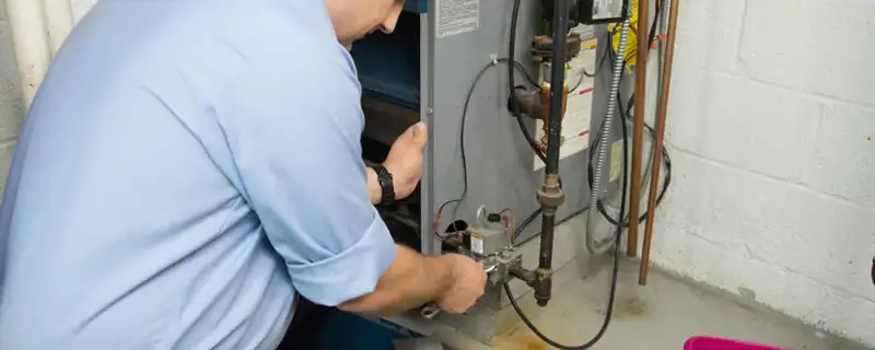Furnace repair technician inspecting and servicing a home heating system in Portland, OR