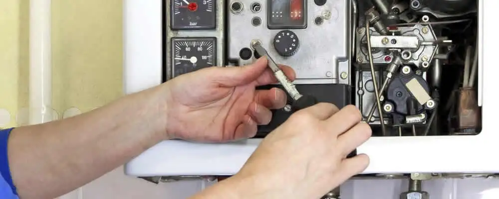 Heating repair technician adjusting boiler controls and components in Portland, OR