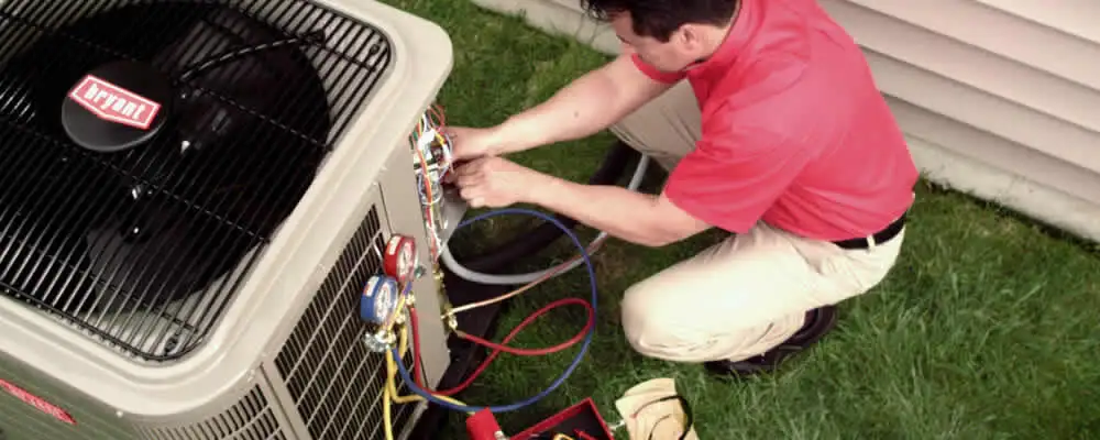 HVAC technician servicing an outdoor air conditioner unit in Portland, OR
