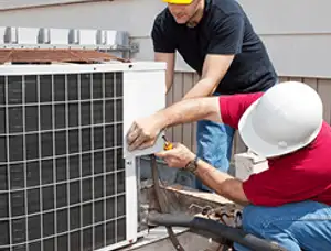 HVAC technicians repairing an outdoor AC unit on a rooftop in Portland, OR