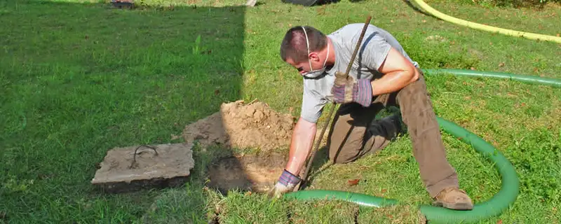Septic pumping technician servicing a residential septic tank in Portland, OR
