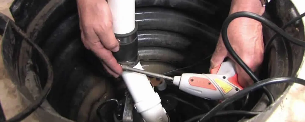 Sump pump installation technician connecting PVC discharge piping in Portland, OR