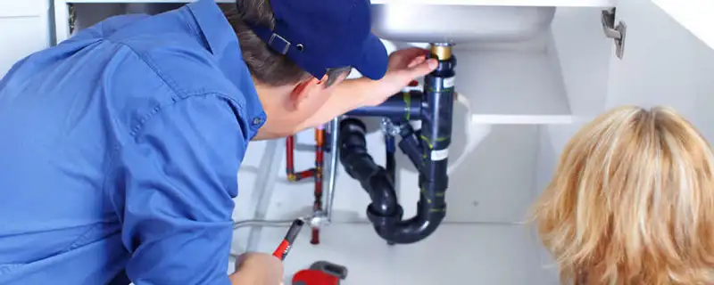 Plumber repairing under-sink drain pipes and fittings in Portland, OR